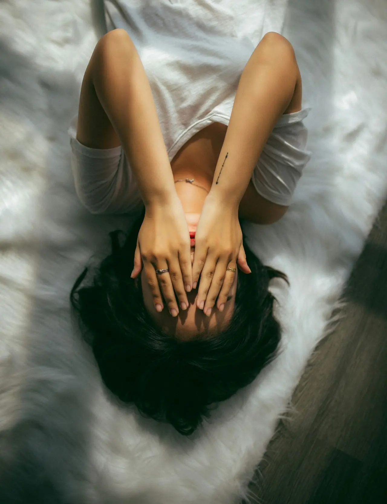 a woman holds her hands over her face